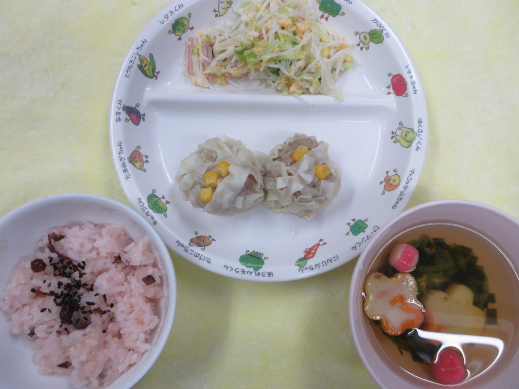 【卒園のお祝い給食】卒園式の前日のお祝い給食です。甘納豆を使ったお赤飯とホタテ入りの花焼売で子どもたちの門出をお祝いしました。